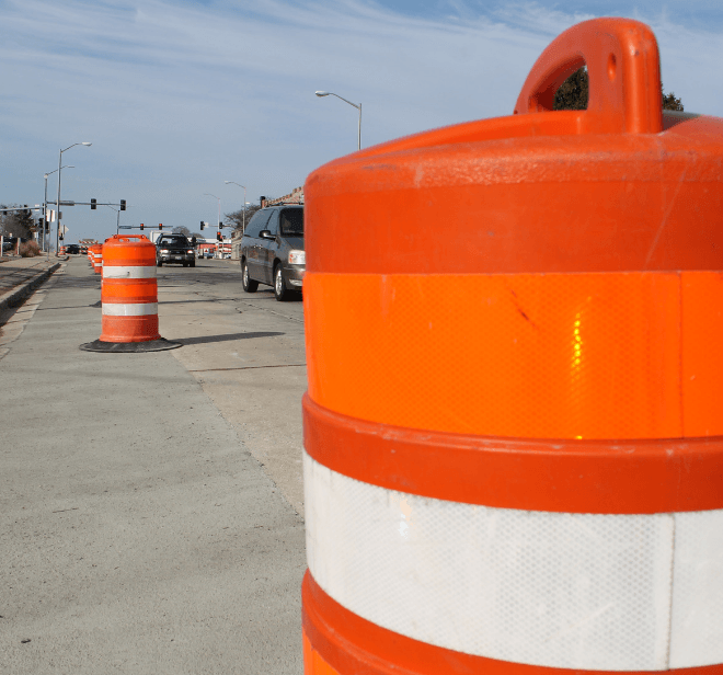  A row of orange and white construction cones lined up on a road