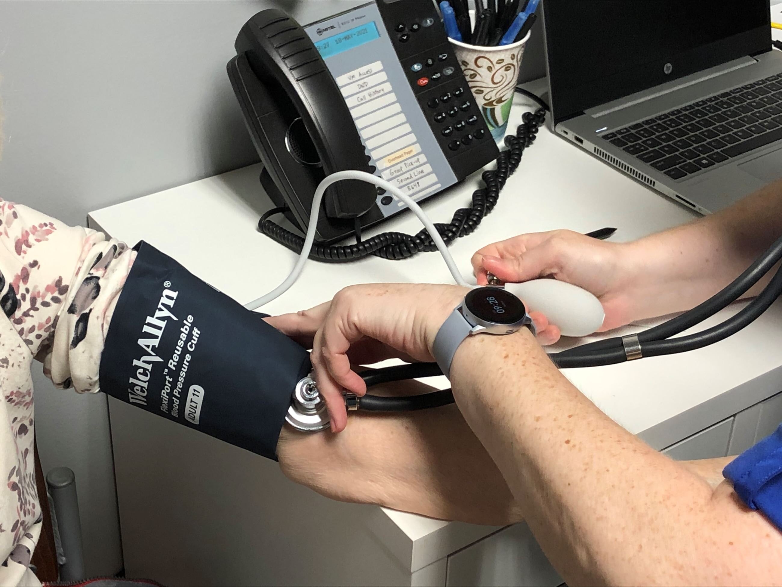 A doctor measures a woman's blood pressure using a cuff