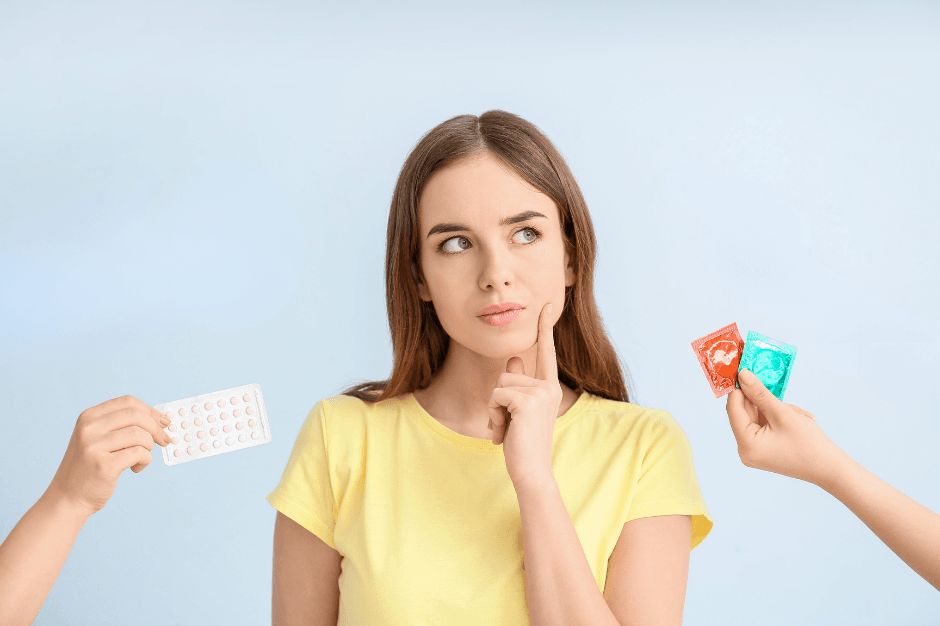 A woman displays a pill box and a condom