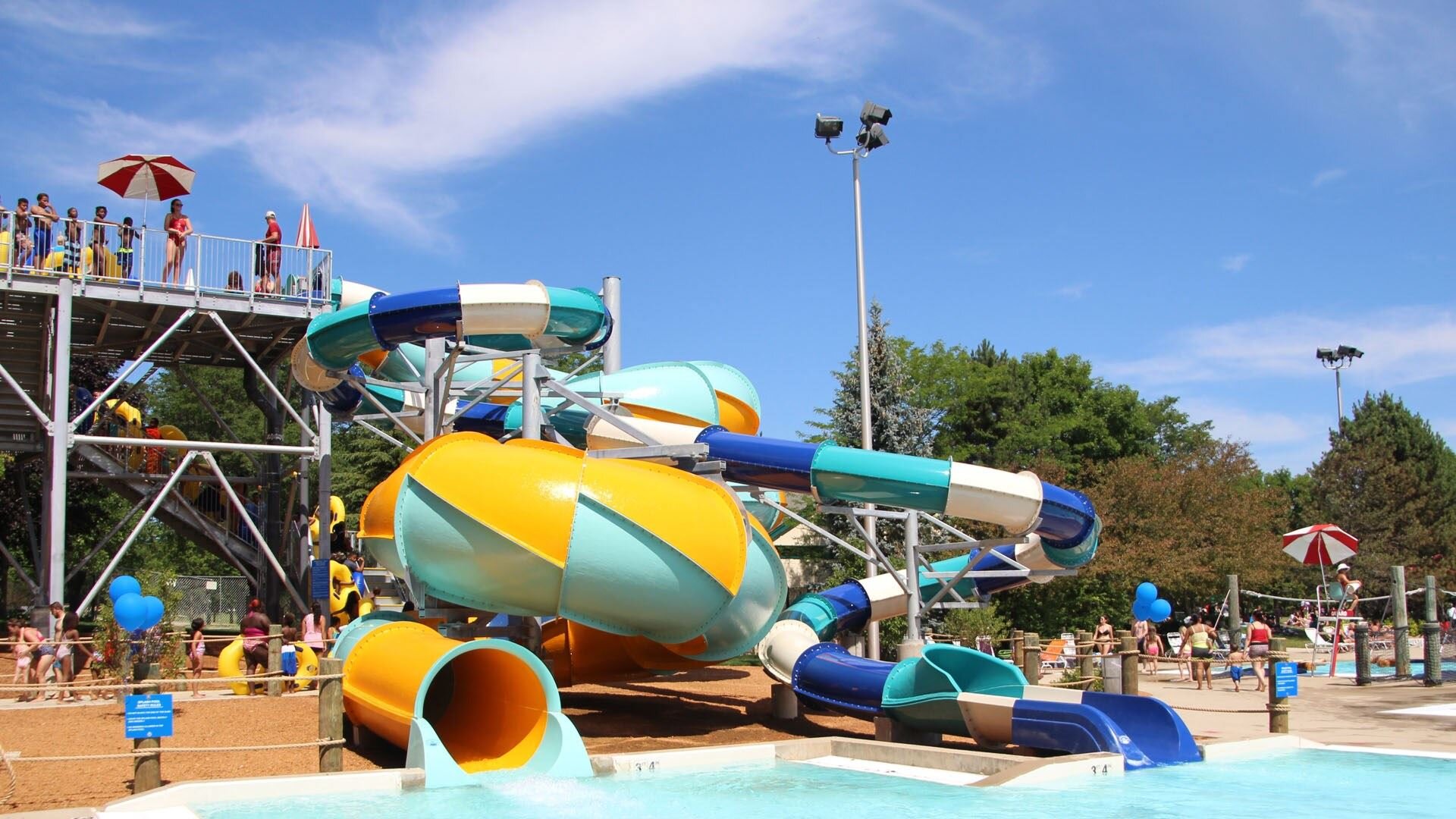 A lively water park scene showcasing a big slide and a water slide