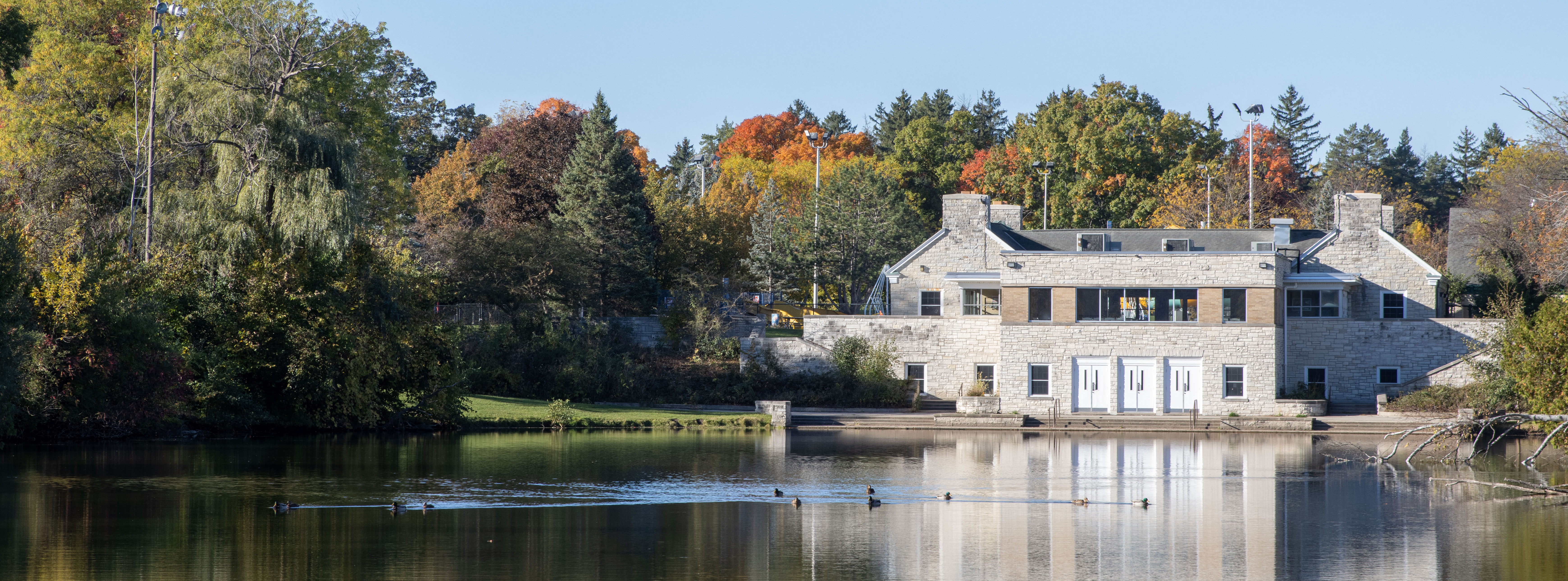 Peaceful photo of the pond at Greenfield Park  and the park pavilion in fall.