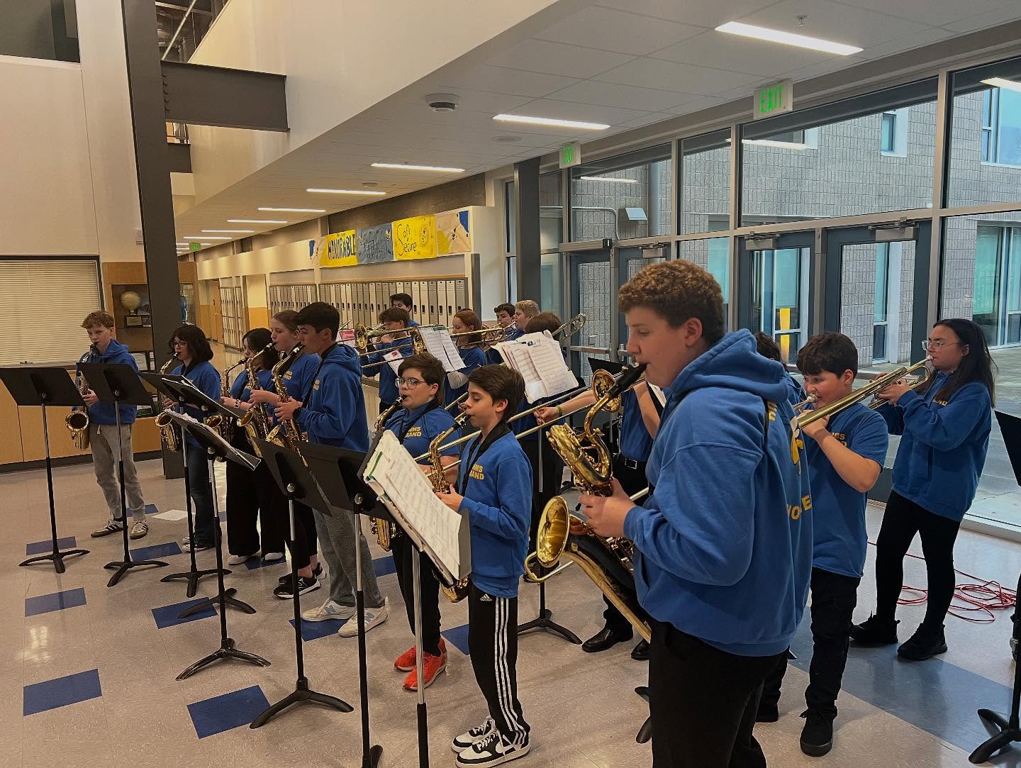 Middle school students play instruments in school foyer