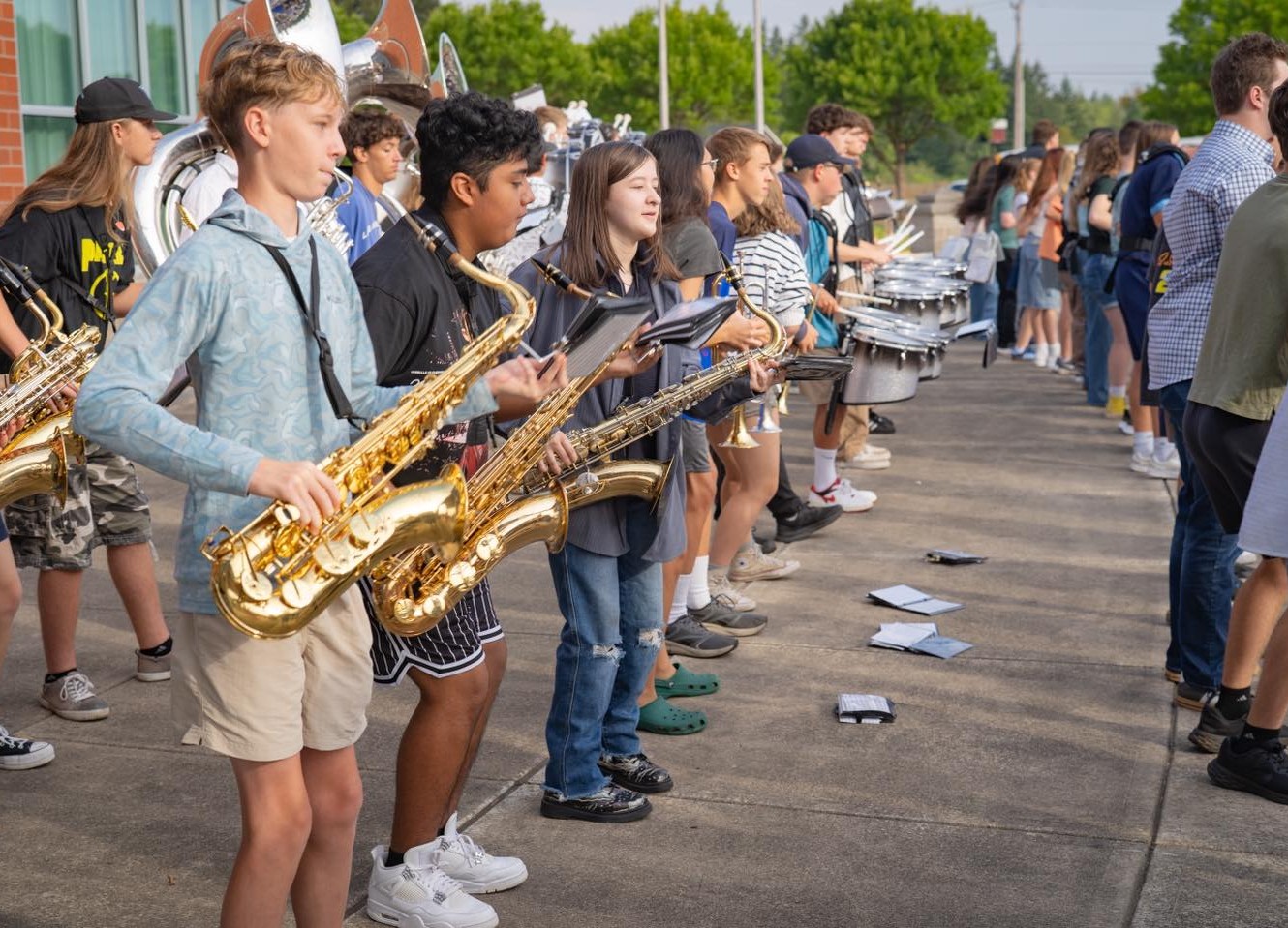 High school students play instruments outdoors