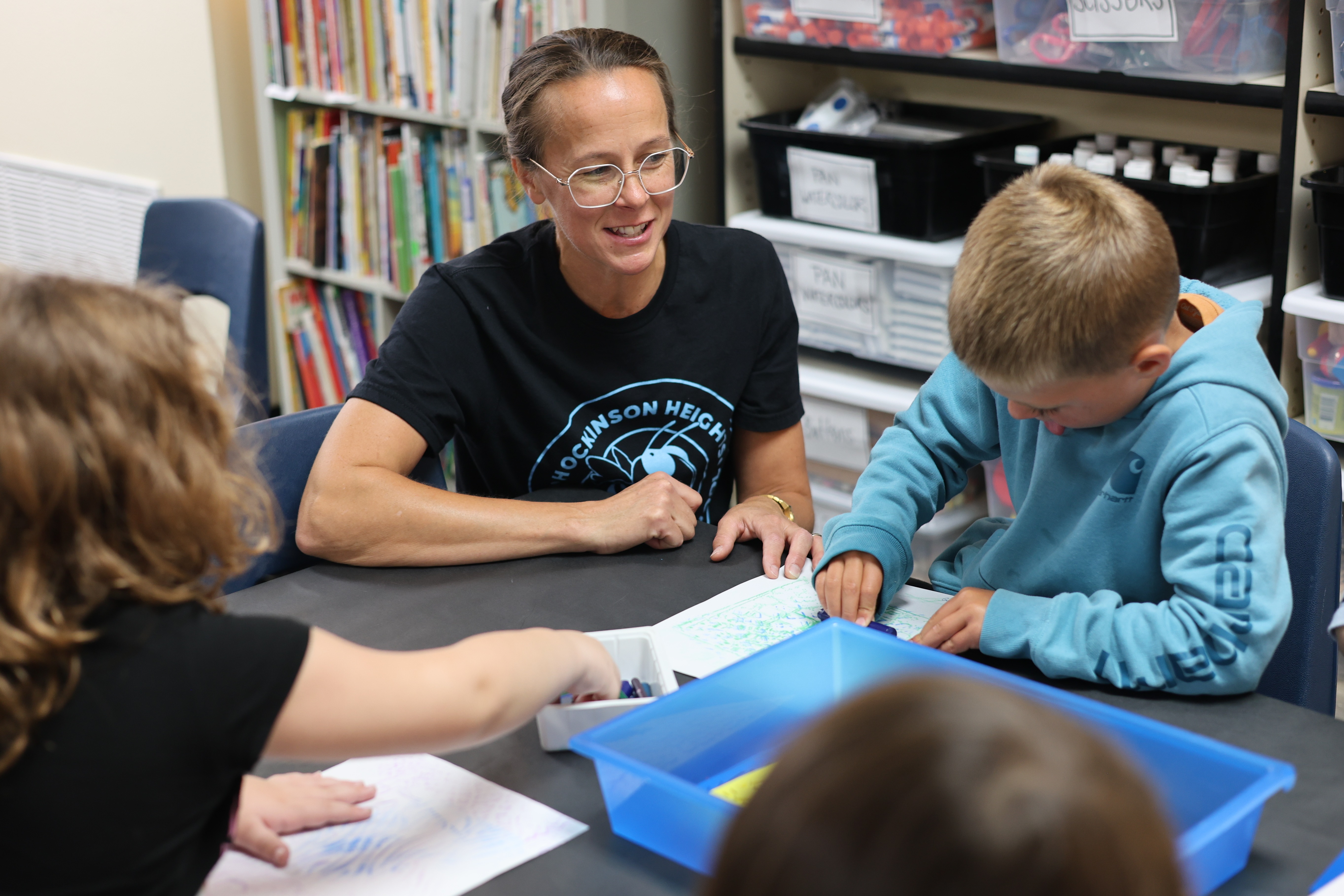 Art teacher assisting a student in art class