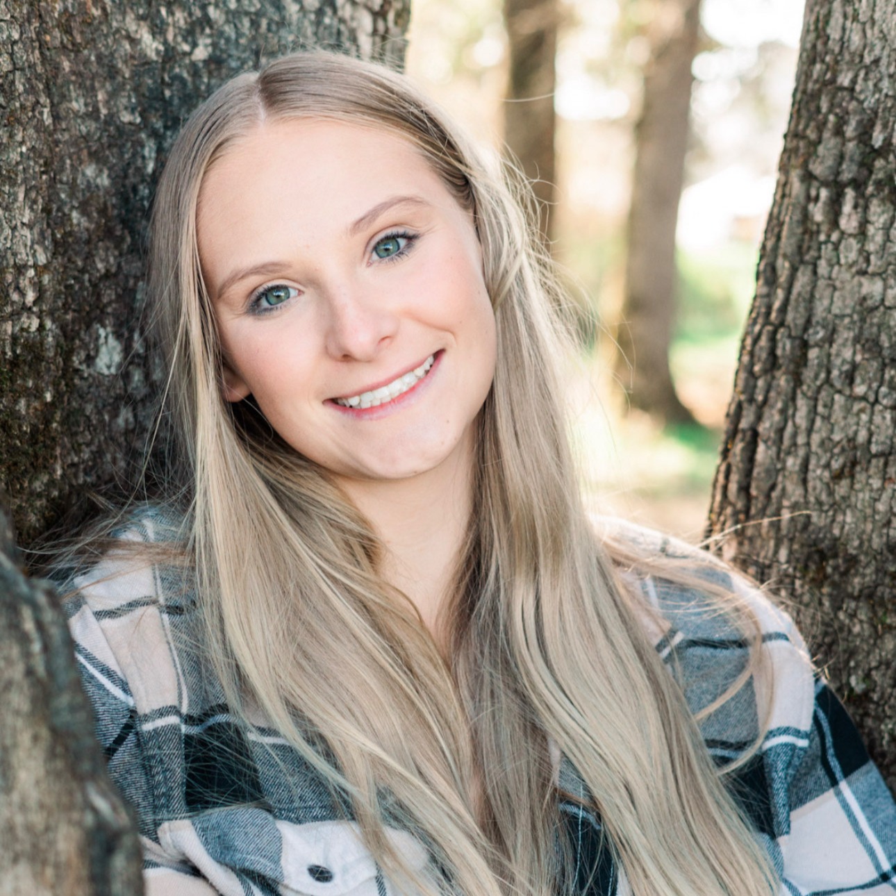 Photo of a staff member who is standing in front of a tree