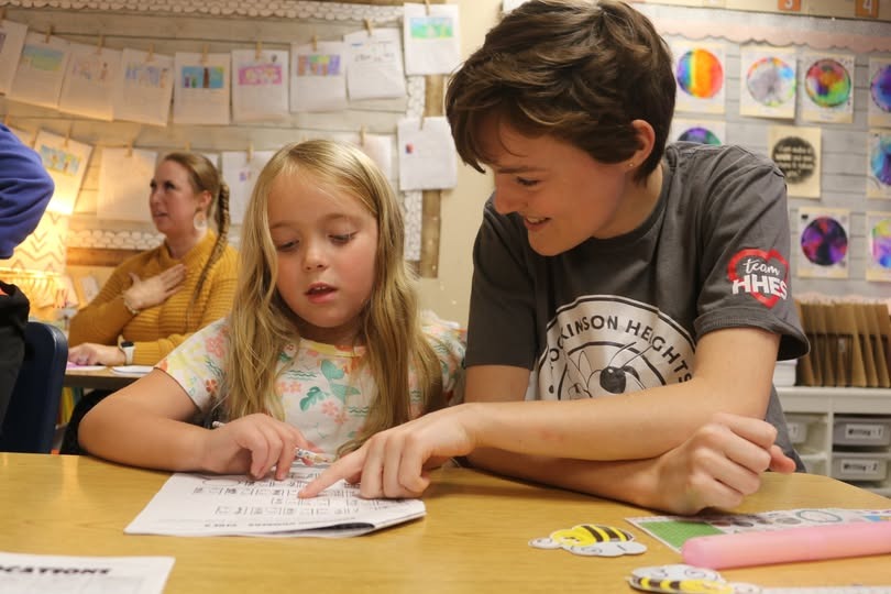 Student studies in class with help of an Americorps staff member