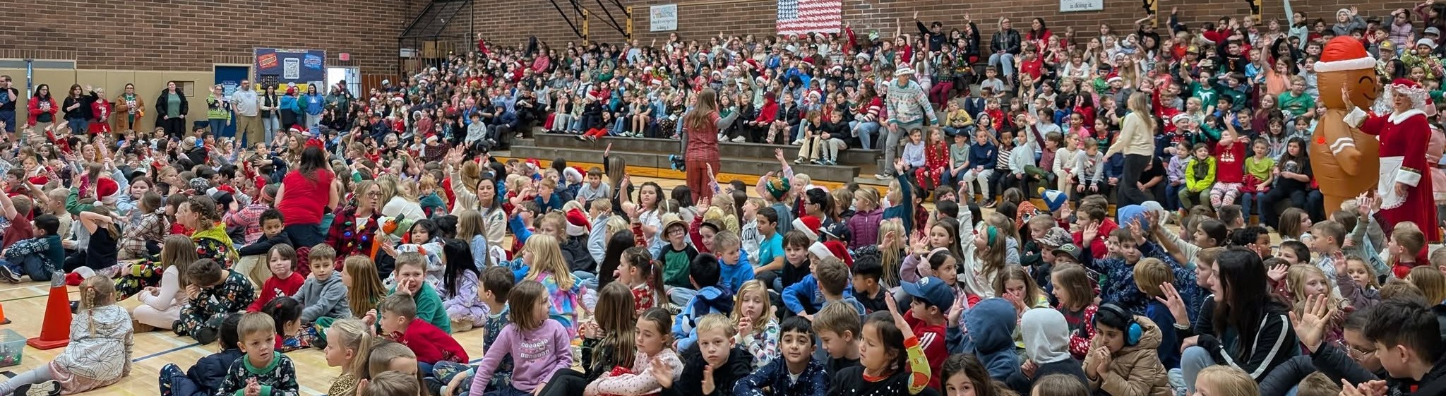 Group of elementary students sitting in a gymnasium