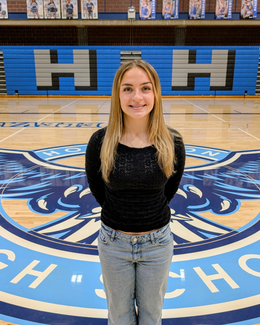 Student stands on gym floor
