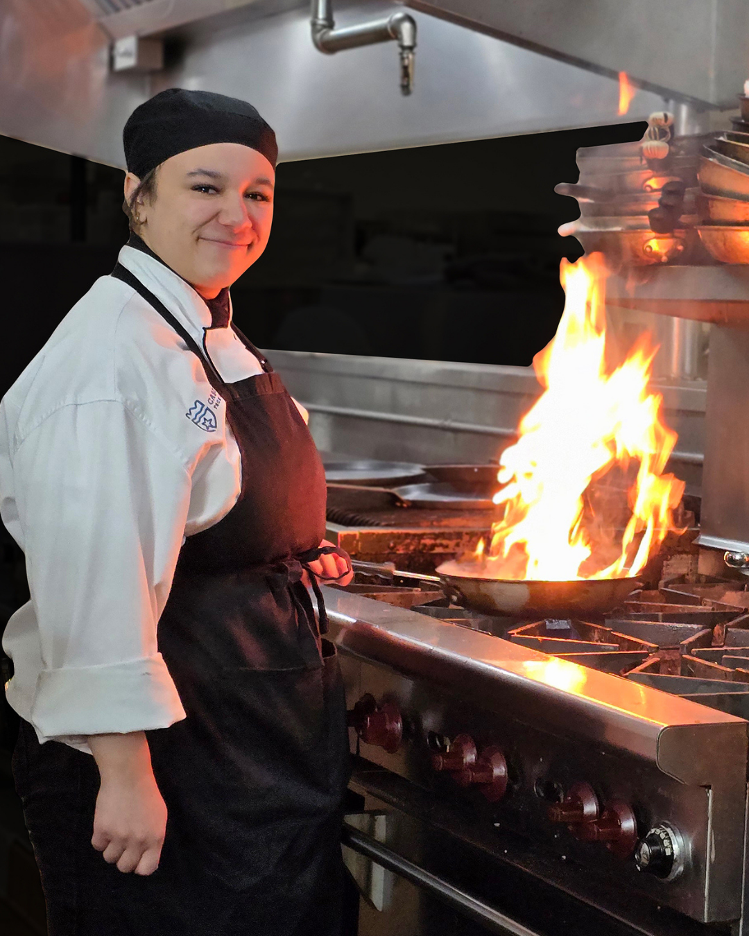 Student cooks over a flaming pan