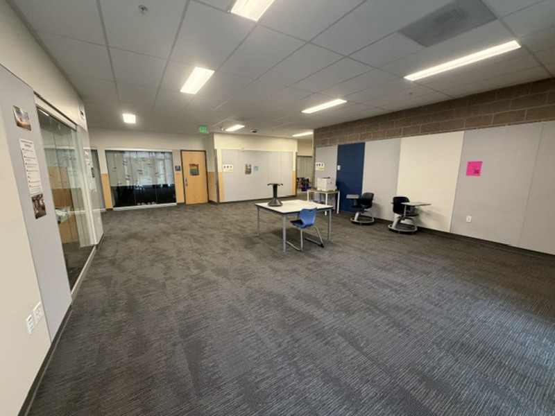 Indoor photo of a common area with classroom doors.