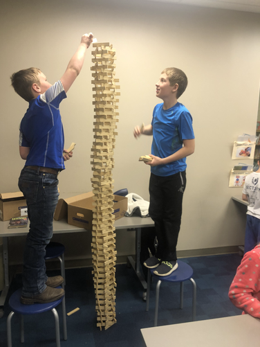 A group of young men standing next to each other in front of a tall tower