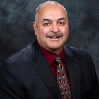 A man in a suit and tie sitting on a chair.