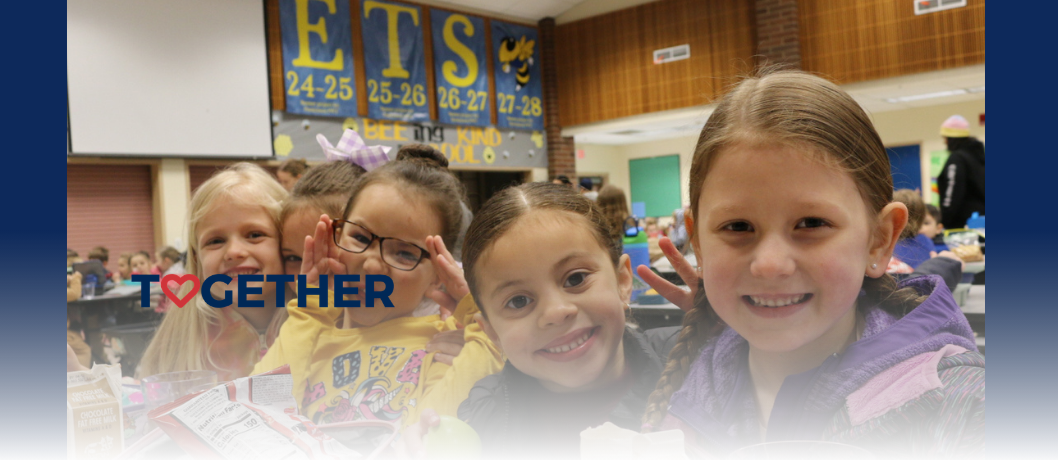 Kindergarten students together at the lunch table.