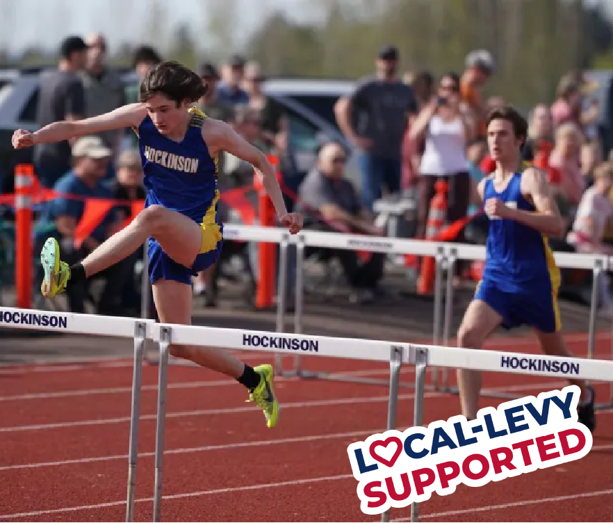 Boy jumping over hurdles on a track
