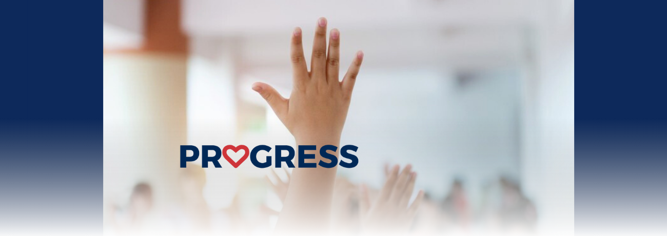 Students' raised hand in a classroom.