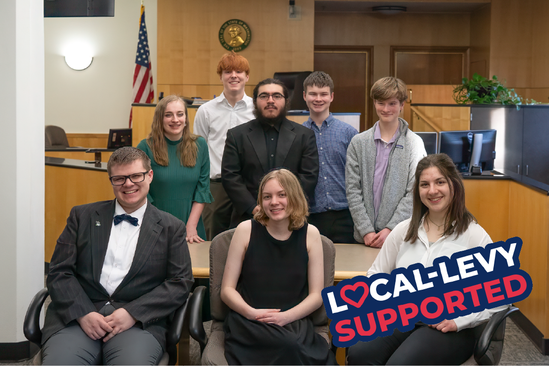 Students in mock trial pose in a court room
