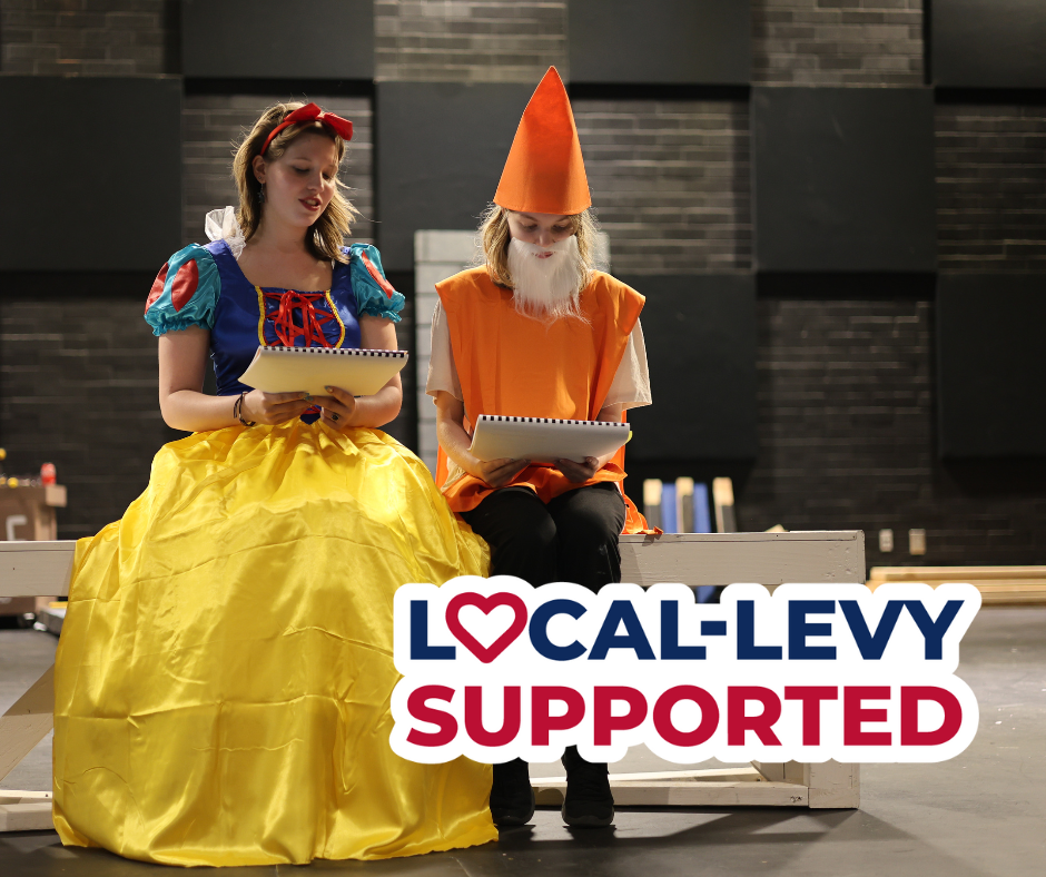 Girl dressed in snow white costume with girl dressed in dwarf costume. Text overlay reads Local Levy Supported.