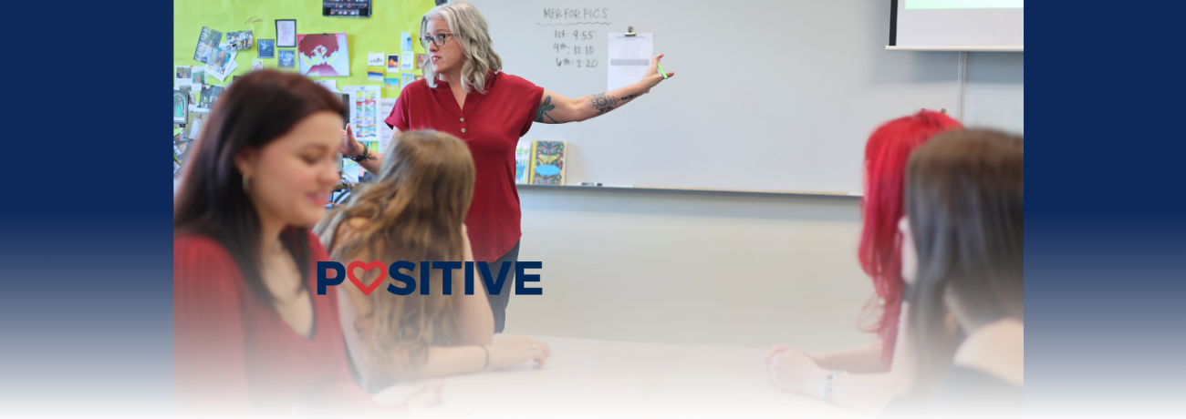 An HHS teacher stands at the front of her classroom.