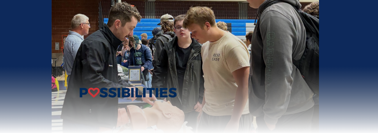 HHS students at the 2026 LAUNCH fair speak to a medical professional about his profession.