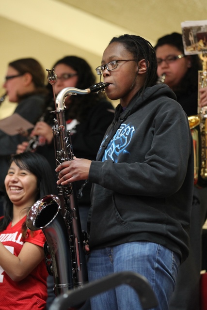 A woman playing a saxophone in front of a group of people