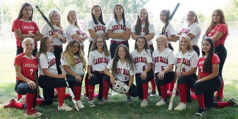 Softball team smiling together for group photo.