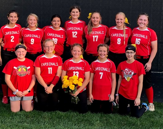 Softball team smiling together for group photo.