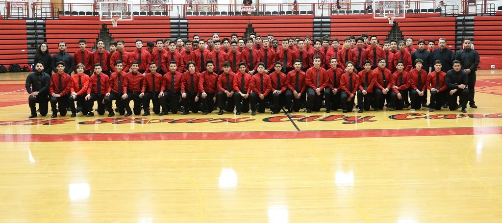 Group of men wearing red shirts on court.