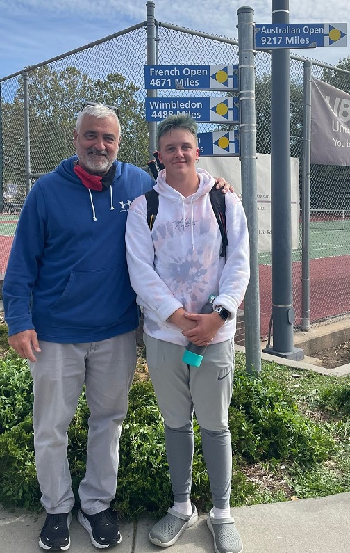 Two men standing on a tennis court, holding tennis rackets.