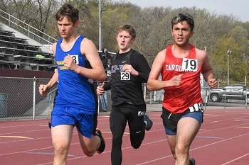 Three young men sprinting on a track, competing in a race, showcasing determination and athleticism.