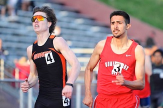Two men sprinting on a track during a race.