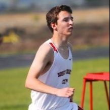 Person running in boys 800m race at track and field meet.