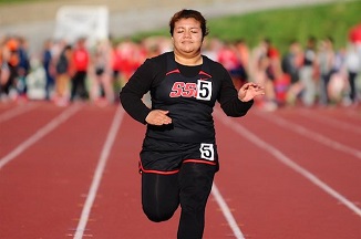 A female athlete sprinting on a track during a race.