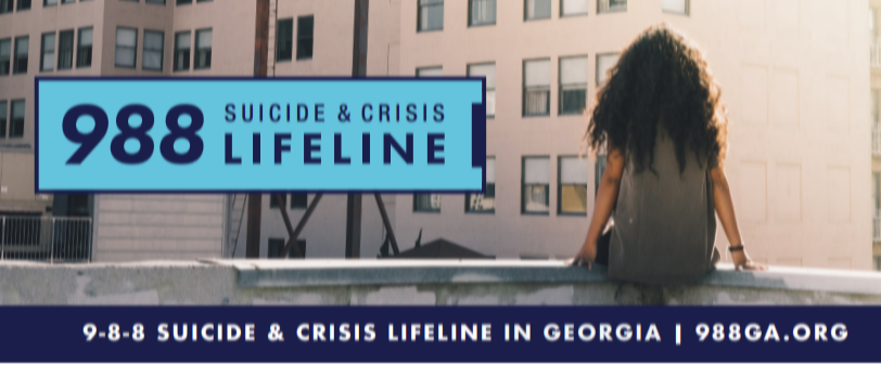A person sits on a rooftop overlooking a large billboard that reads “988 Suicide & Crisis Lifeline.” A banner along the bottom reads, “9-8-8 Suicide & Crisis Lifeline in Georgia | 988GA.org.”