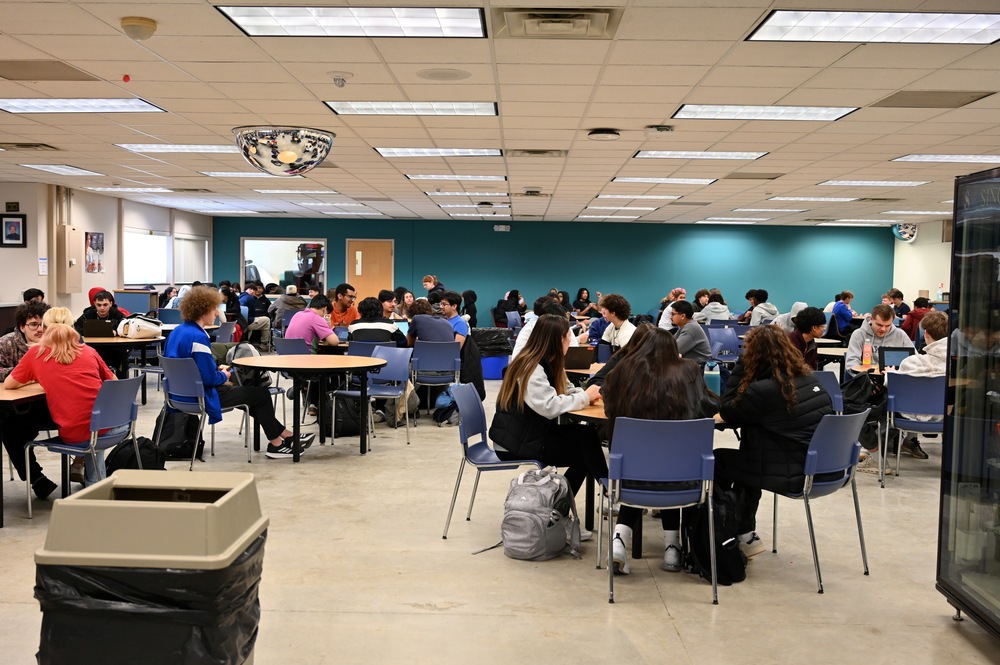 An image of students dining at tables in what was formerly the library and is temporarily serving as the "cafe."