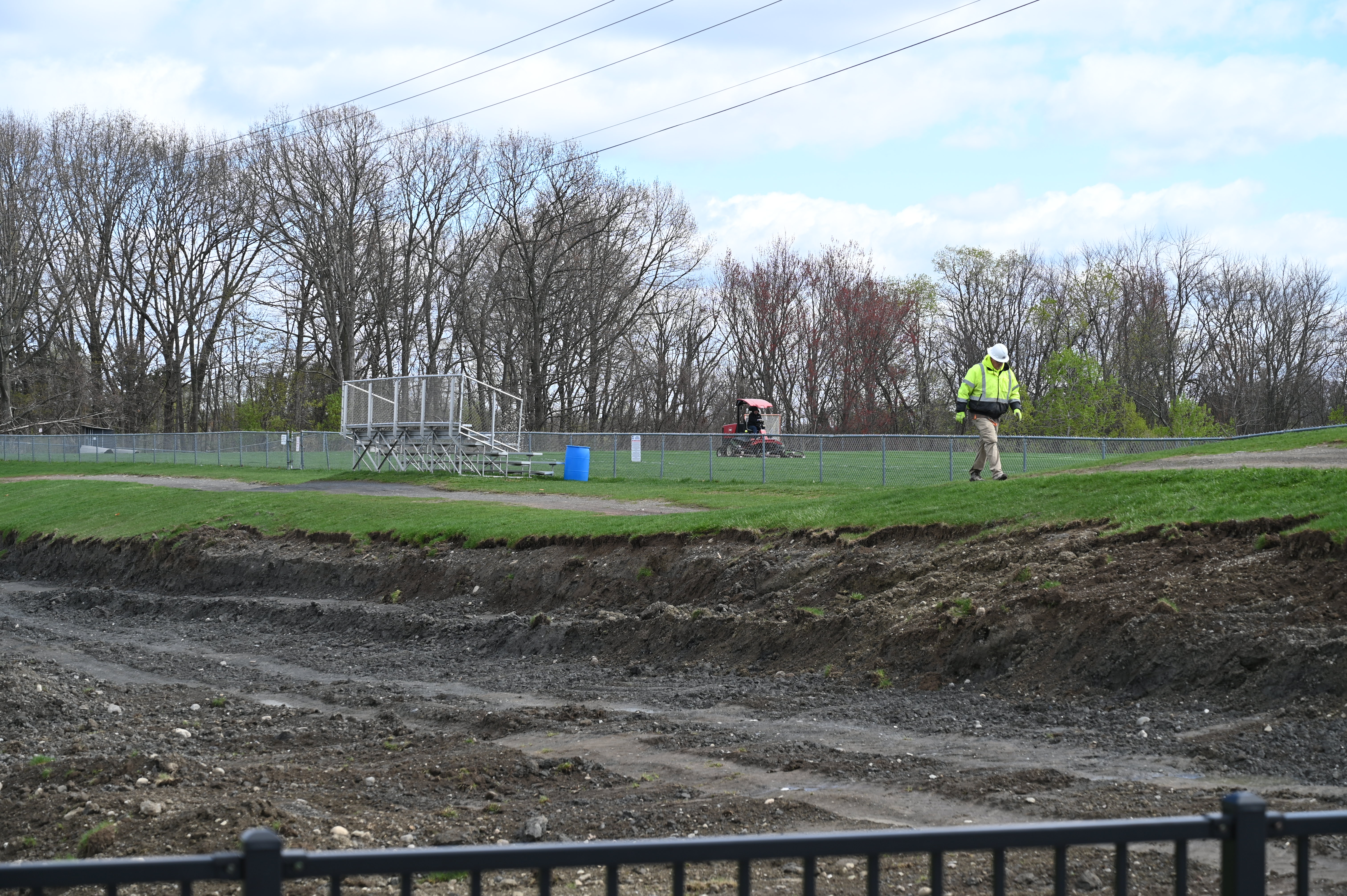 A construction worker walks along dug up ground outside Shaker High School.