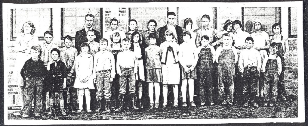 A vintage black and white photograph depicting a group of children gathered together, showcasing their joyful expressions.