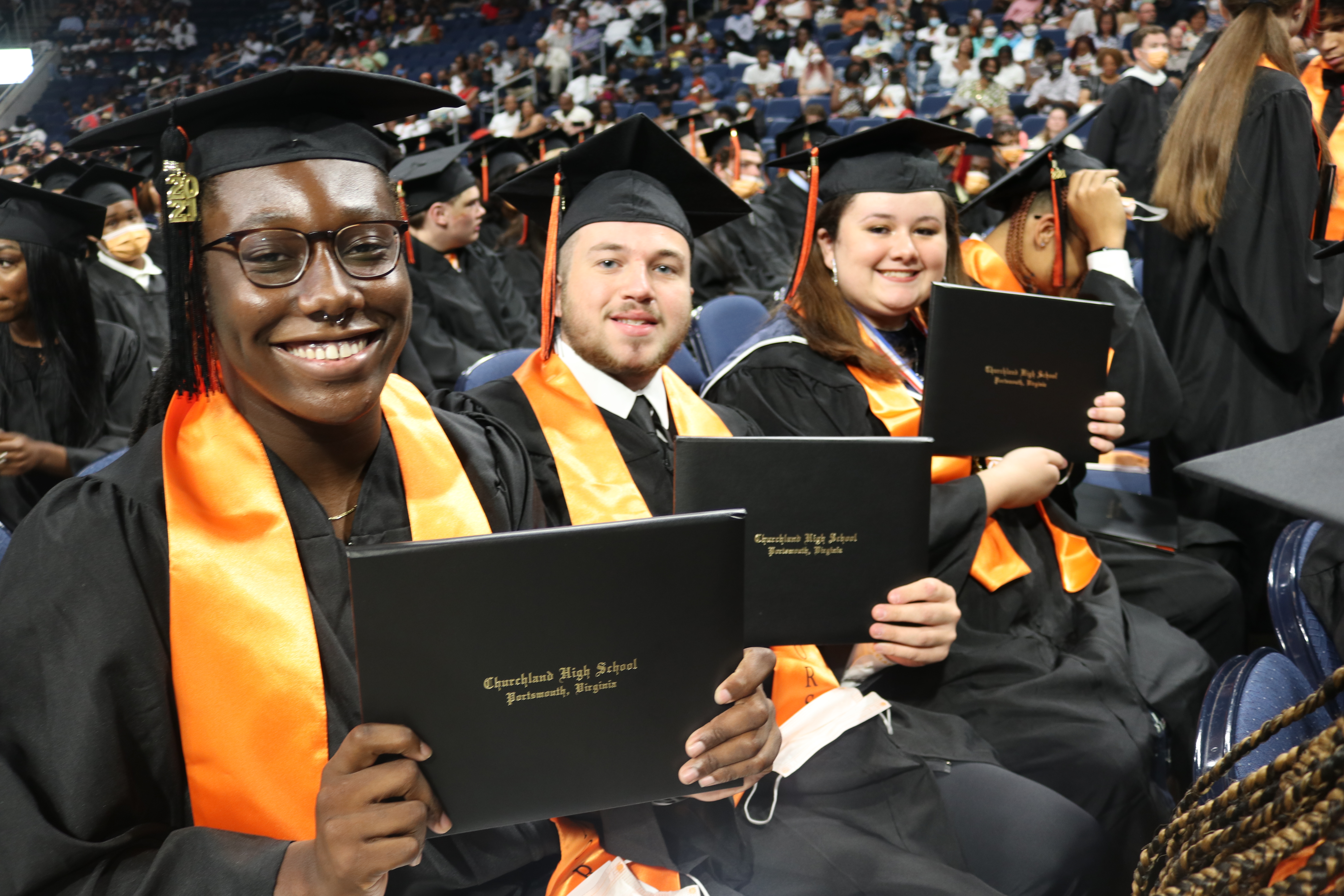 Graduates celebrating with diplomas.