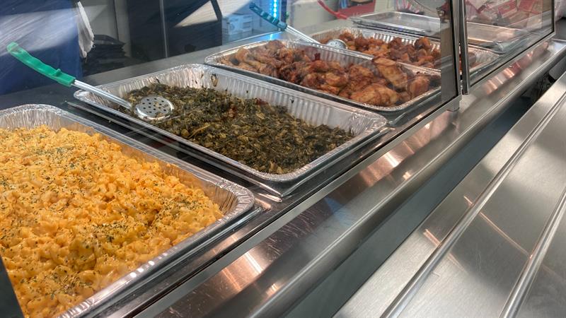 A tray with an assortment of food items, including casseroles and chicken, ready to be served.