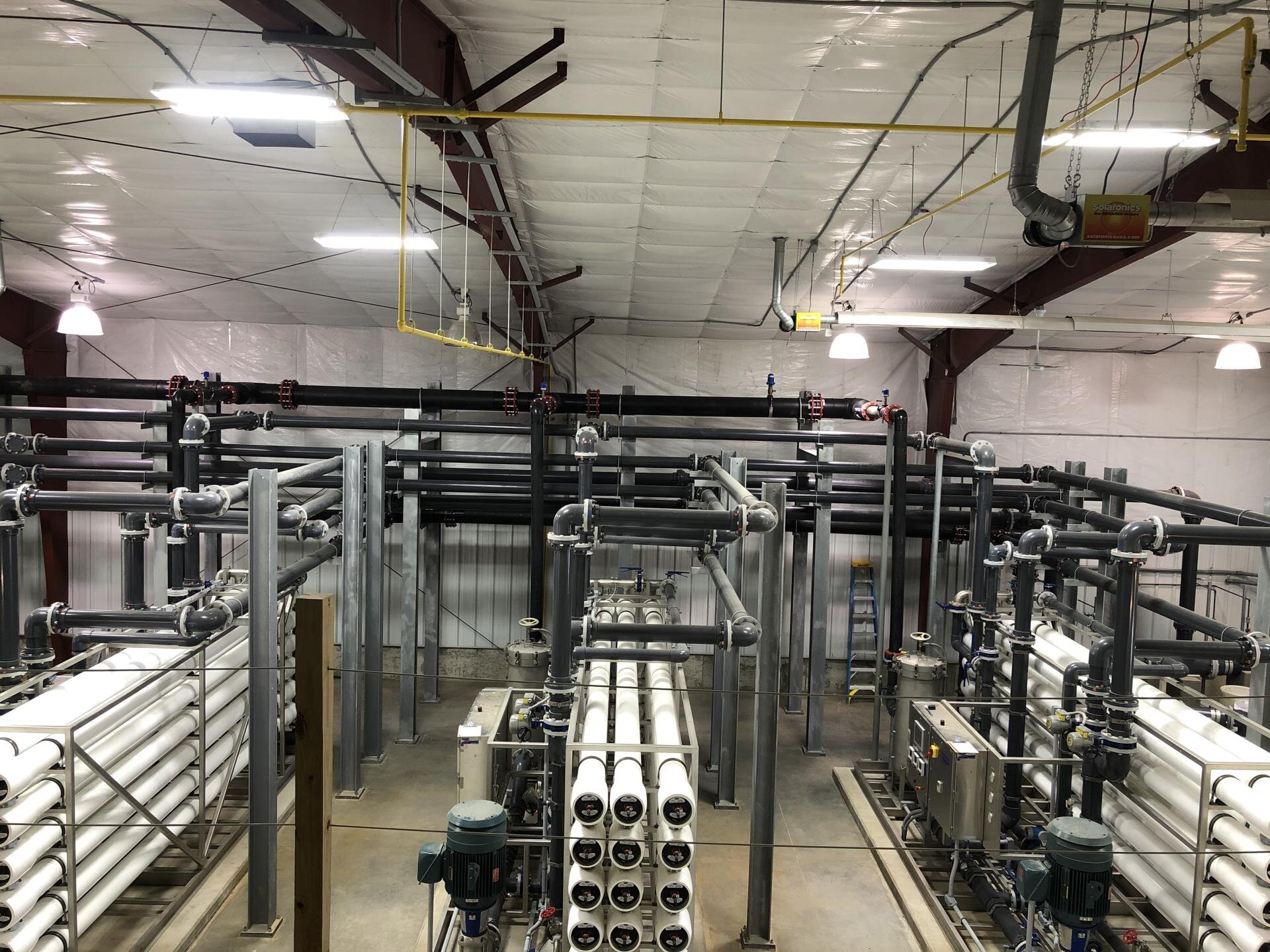 A spacious room filled with various pipes running along the walls and ceiling