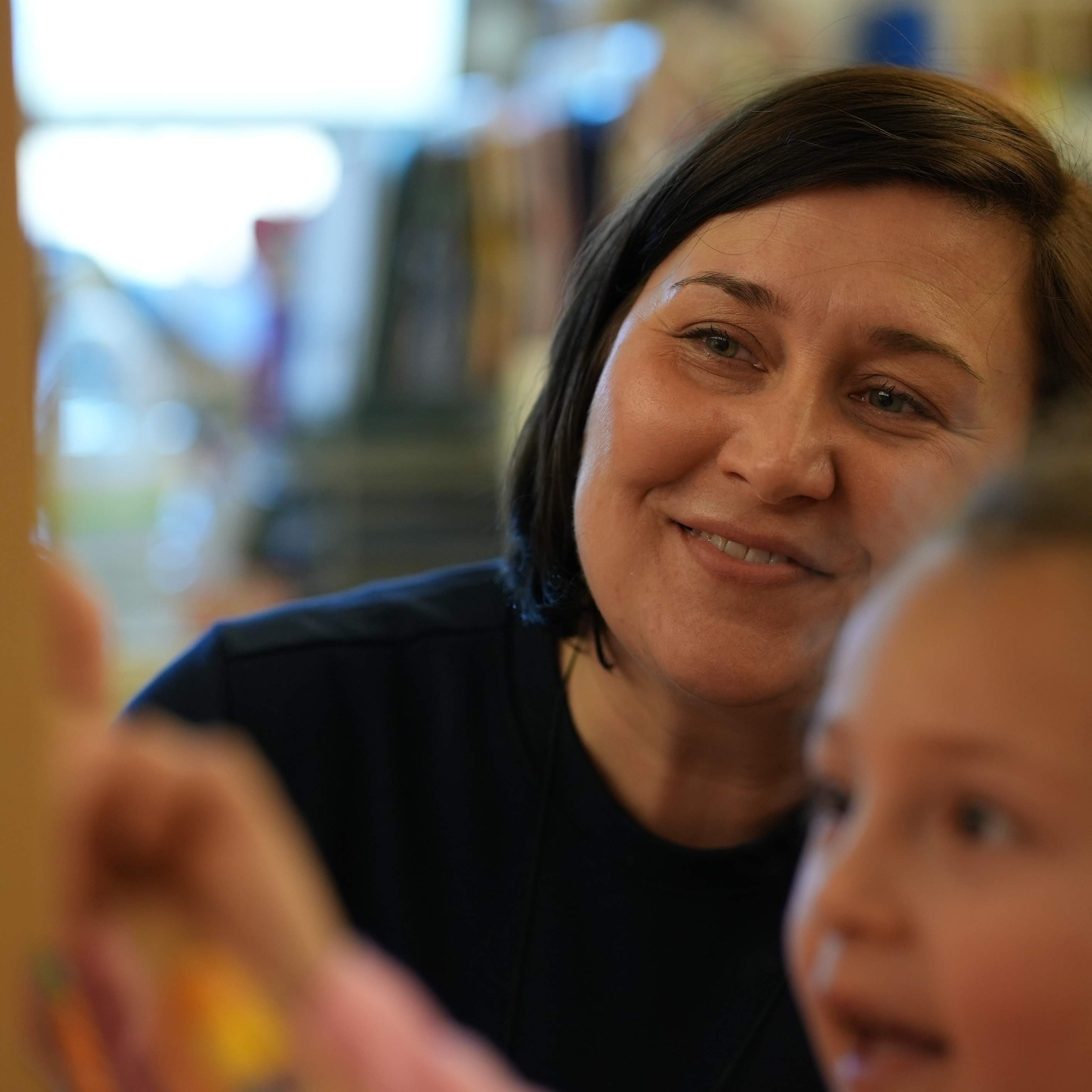 Teacher talking to students as they draw