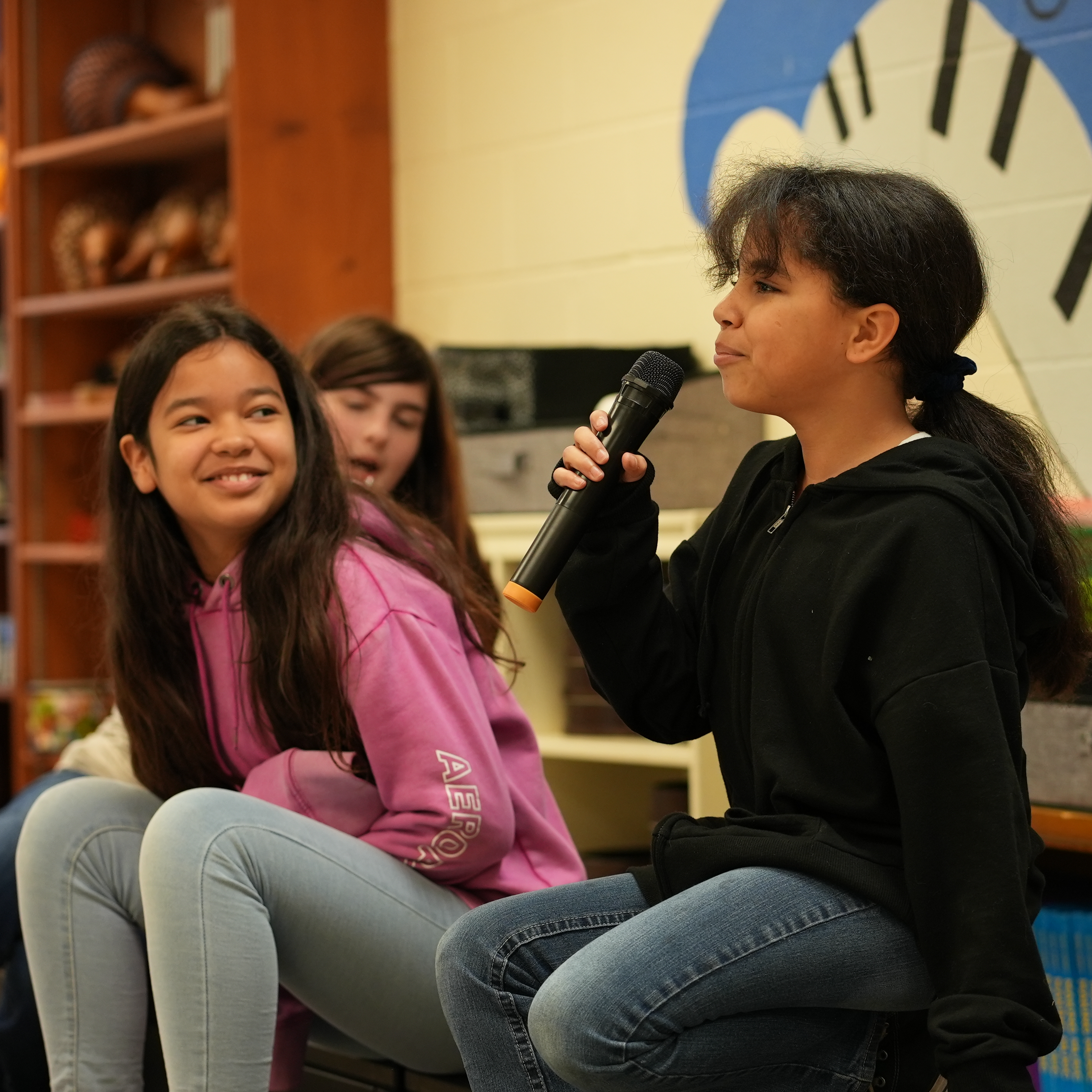 students speaking to peers using a microphone