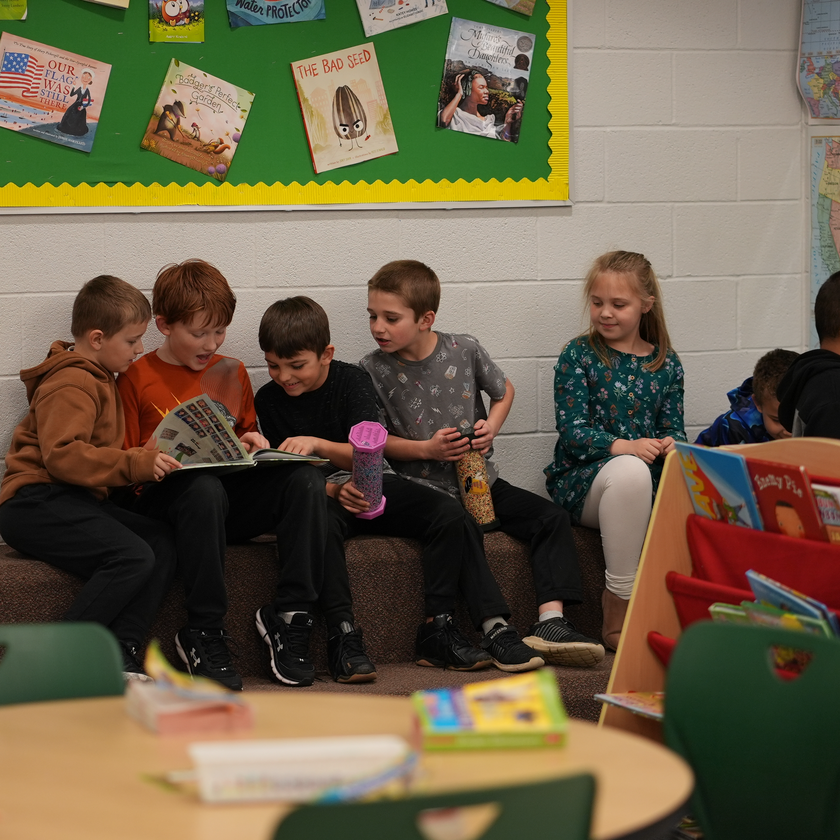 Students in a small group sharing a book in the library