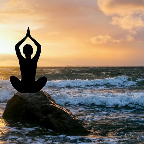 Person doing yoga in the beach