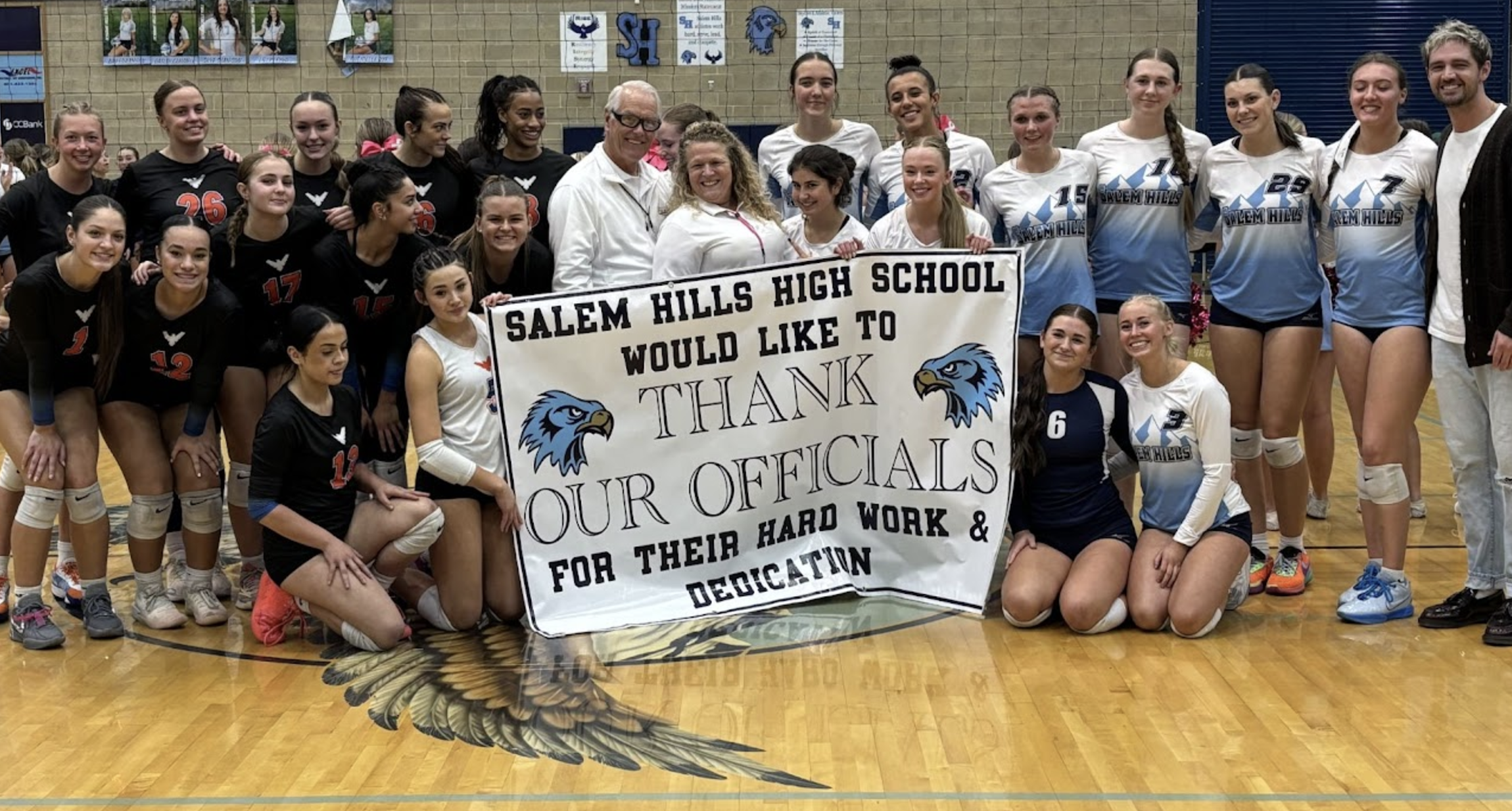 Girls Volleyball team with officials thank you sign