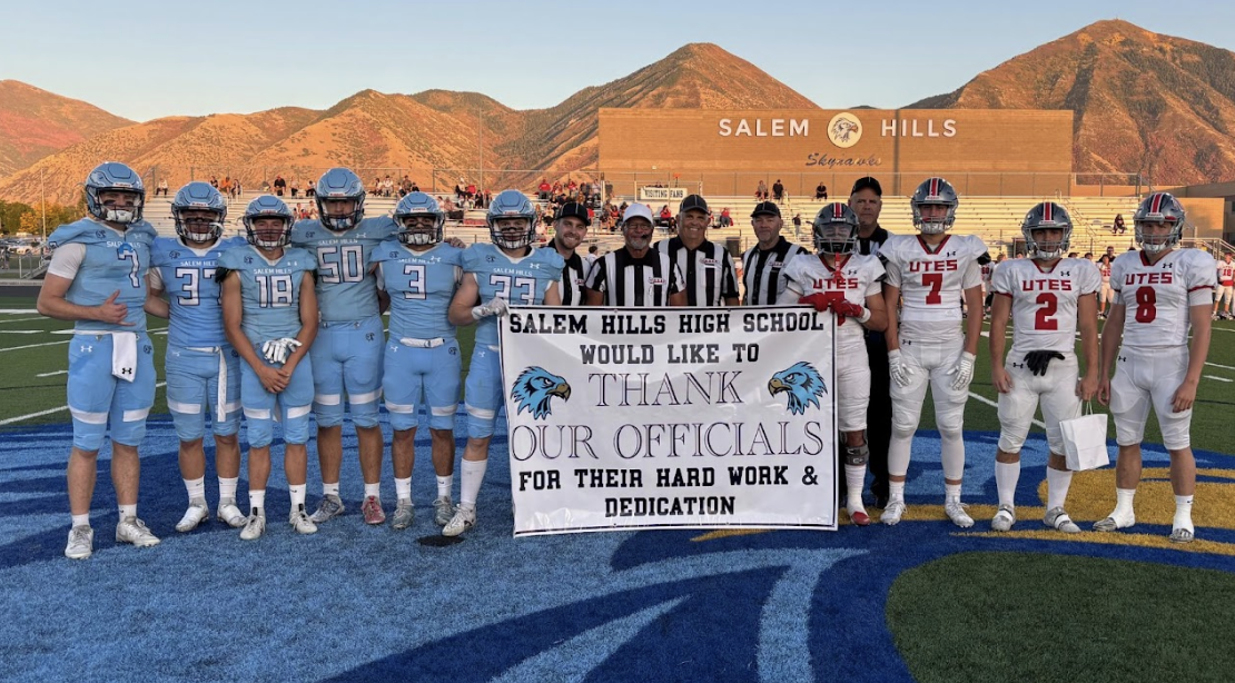 Football team with official's thank you banner