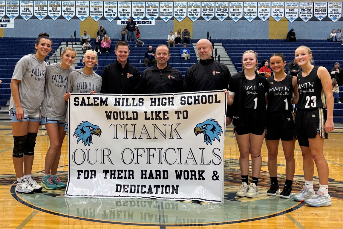 Girls basketball team with officials thank you sign