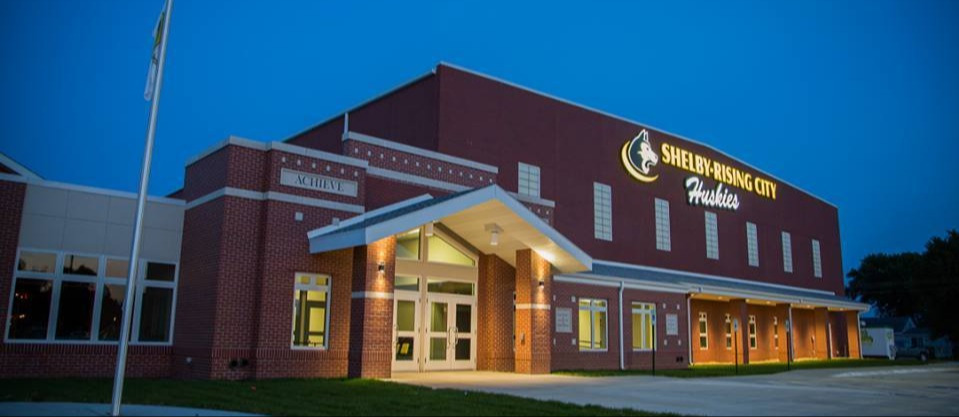 Facade of the Shelby Rising Public School with Shelby Rising City Huskies and the Mascot written on it 