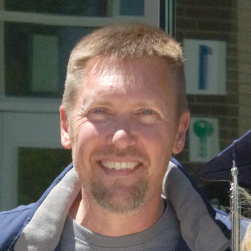 Photo of a male principal smiling in the sunshine