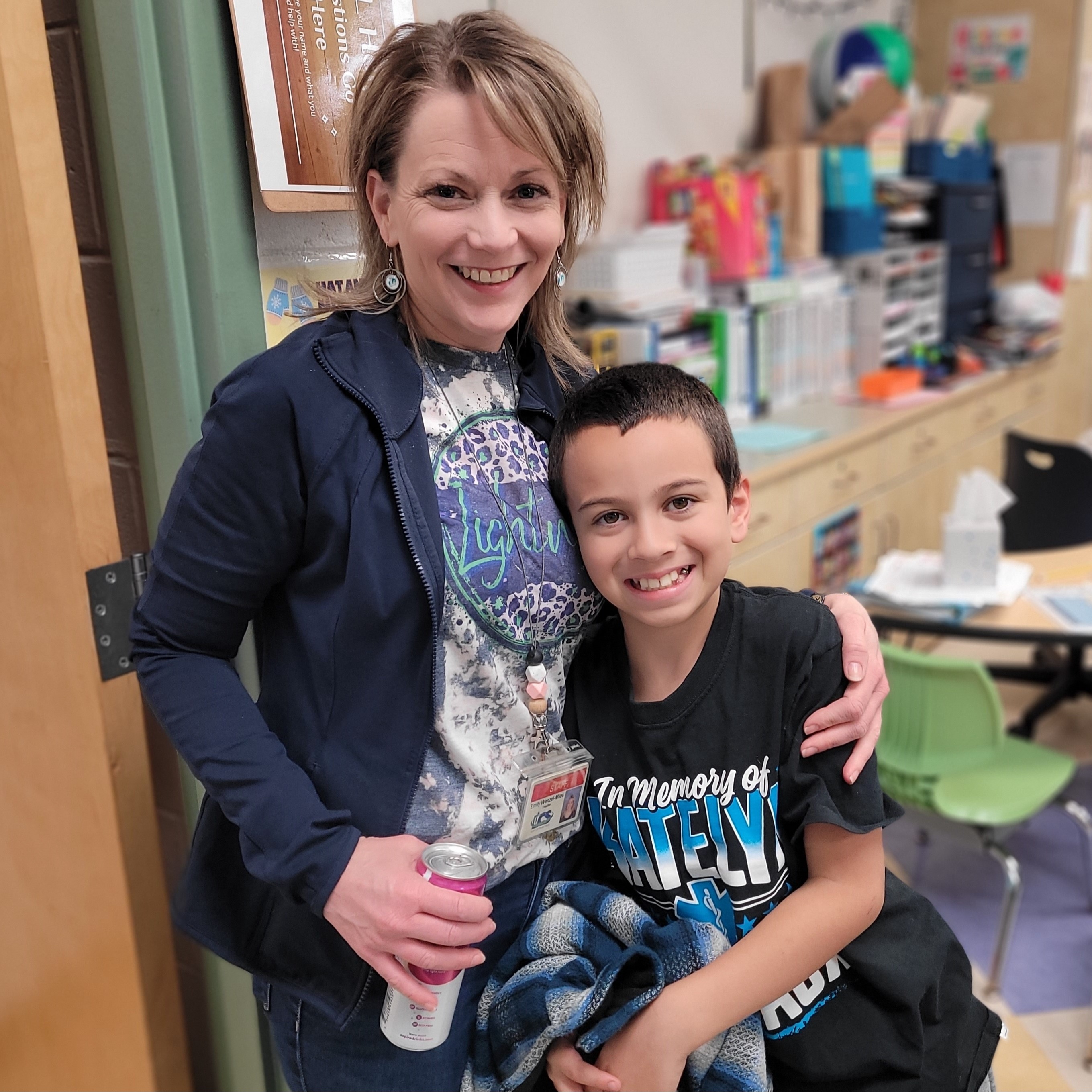 Elementary female teacher smiling with a male student