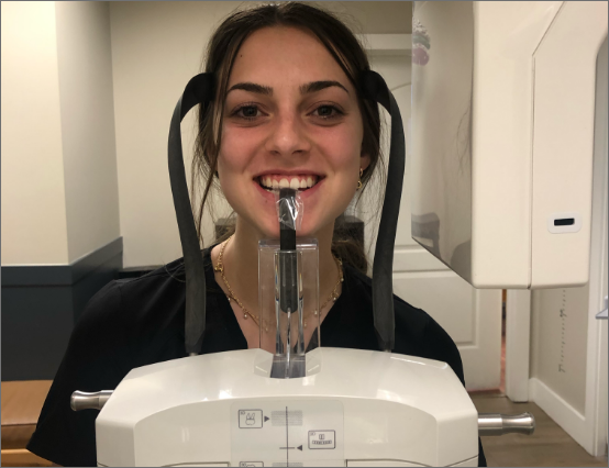 student posing in front of dentist tools